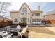 Large backyard featuring a deck with dining table and chairs, a fire pit and seating, and manicured landscaping at 3350 Fieldwood Se Dr, Smyrna, GA 30080