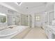 Bright main bathroom featuring a jacuzzi tub, glass shower, skylight and dual vanity at 3350 Fieldwood Se Dr, Smyrna, GA 30080