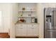 Convenient butler's pantry with stainless steel refrigerator, stylish cabinetry, and open shelving, perfect for storage and organization at 827 Derrydown Way, Decatur, GA 30030