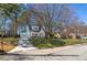 Inviting two-story home with a manicured front lawn, mature trees, and a long driveway leading to a detached garage at 827 Derrydown Way, Decatur, GA 30030