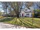 Beautiful two-story home with a red front door, black shutters and lovely landscaping, surrounded by mature trees at 827 Derrydown Way, Decatur, GA 30030