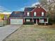 Charming two-story red brick home with a two-car garage and basketball hoop on a sunny day at 2703 Regal Cir, Conyers, GA 30012