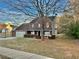 Two-story red brick home with a spacious front yard and mature tree, providing shade and curb appeal at 2703 Regal Cir, Conyers, GA 30012