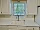 Close up of the kitchen sink and window with white cabinetry and tile backsplash at 2703 Regal Cir, Conyers, GA 30012