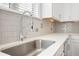 Close up of a kitchen featuring subway tile backsplash, stainless steel sink, and quartz countertops at 1800 Morning Glory Ne Ln, Atlanta, GA 30324