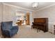 Bright living room features an accent chair, a piano, and opens into a dining room with a glass cabinet at 1135 Banbury Cross, Avondale Estates, GA 30002