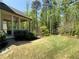 Lush backyard featuring green lawn, mature trees, and a covered porch perfect for outdoor enjoyment at 5210 Timber S Trl, Sandy Springs, GA 30342
