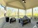 Covered patio with stone flooring and comfortable seating with a wooded view at 5210 Timber S Trl, Sandy Springs, GA 30342