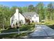 Charming two-story white home featuring a well-manicured lawn, a long driveway and a chimney at 5210 Timber S Trl, Sandy Springs, GA 30342