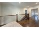 Upstairs hallway with hardwood floors, wrought iron railings, and doorway to another room at 5210 Timber S Trl, Sandy Springs, GA 30342