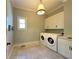 Well-lit laundry room features a washer, dryer, tile flooring and ample storage cabinets at 5210 Timber S Trl, Sandy Springs, GA 30342