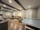 Spacious living area features dark wood beams, hardwood flooring, and a gray ping pong table at 5210 Timber S Trl, Sandy Springs, GA 30342