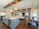 Open concept kitchen and living room with exposed beams, large island, and dining space at 5210 Timber S Trl, Sandy Springs, GA 30342