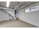 Unfinished basement space with a carpeted floor, window, and access to the stairwell at 9760 Greenside Way, Douglasville, GA 30135