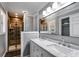 Modern bathroom with a double sink vanity, decorative mirror, and a walk-in tiled shower at 9760 Greenside Way, Douglasville, GA 30135