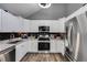 Modern kitchen with white cabinets, stainless steel appliances, and dark backsplash at 9760 Greenside Way, Douglasville, GA 30135