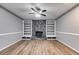 Spacious living room with a stone fireplace, built-in shelving, and hardwood floors at 9760 Greenside Way, Douglasville, GA 30135