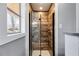 Modern shower featuring wood-look tile, a glass shower door, and a shower head with handle at 9760 Greenside Way, Douglasville, GA 30135