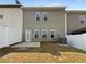 A green home's backyard features a small patio, white fences, and a compact lawn at 27 Crescent Chase, Dallas, GA 30157