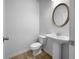 Powder room featuring a pedestal sink, oval mirror and wood-look flooring at 27 Crescent Chase, Dallas, GA 30157