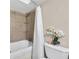 Well-lit bathroom featuring a shower-tub combo, tiled walls, and modern fixtures at 395 Pharr Ne Rd # 305, Atlanta, GA 30305