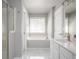 Bright bathroom featuring a soaking tub, glass shower, and marble floors at 402 Iona Abbey Se Ct, Smyrna, GA 30082