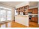 Sunlit kitchen features stainless steel appliances, wood cabinets, and access to the patio at 402 Iona Abbey Se Ct, Smyrna, GA 30082