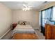 Bright bedroom with wooden furniture, ceiling fan, window with curtains, and natural-colored walls at 7881 Wilkerson Ln, Palmetto, GA 30268