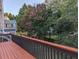 View of the backyard from wood deck with railing, featuring mature trees and landscaping at 1919 Barrett Knoll Nw Cir, Kennesaw, GA 30152