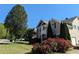 Charming two-story home with lush front lawn, mature tree, and vibrant flowering bushes on a sunny day at 1919 Barrett Knoll Nw Cir, Kennesaw, GA 30152
