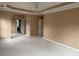 Open main bedroom with tray ceilings, neutral carpet, and attached ensuite bathroom at 1919 Barrett Knoll Nw Cir, Kennesaw, GA 30152