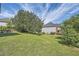 Large grassy backyard with shade trees overlooking a patio and two-story house at 3370 Flagstone Trce, Ellenwood, GA 30294