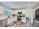 Modern kitchen with stainless steel appliances, white cabinets, and sleek countertops and view to dining area at 3370 Flagstone Trce, Ellenwood, GA 30294