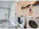Convenient laundry area with modern washer and dryer, shelving, and direct access to front entry and stairway at 3370 Flagstone Trce, Ellenwood, GA 30294