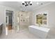 Luxury bathroom with glass enclosed shower, soaking tub, marble floors and a large window at 4827 Basingstoke Dr, Suwanee, GA 30024