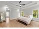 Spacious bedroom with a tray ceiling, hardwood floors, and large windows offering natural light at 4827 Basingstoke Dr, Suwanee, GA 30024