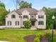 Elegant two-story brick home with black shutters, pristine landscaping, and a well-manicured front lawn at 4827 Basingstoke Dr, Suwanee, GA 30024