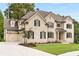Beautiful two-story brick home featuring a three car garage, manicured lawn and dark window shutters at 4827 Basingstoke Dr, Suwanee, GA 30024