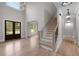Grand foyer with hardwood floors, staircase, and statement lighting fixture at 4827 Basingstoke Dr, Suwanee, GA 30024