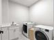 Practical laundry room equipped with a utility sink, modern washer, and dryer at 4827 Basingstoke Dr, Suwanee, GA 30024