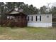 Charming home featuring a covered porch, wood stairs, and neutral siding, nestled among tall trees at 59 Pine Ridge Ln, White, GA 30184