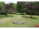 Expansive front yard with scattered trees and a stone-ringed area, offering a natural and spacious setting at 59 Pine Ridge Ln, White, GA 30184