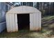 Exterior shot of the storage shed on the property, with a partially open entry at 59 Pine Ridge Ln, White, GA 30184