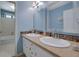 Bright bathroom featuring double sinks, granite countertops, and tiled backsplash at 1527 Ridgewood Sw Dr, Lilburn, GA 30047