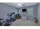 Bedroom with windows, ceiling fan, carpeted floor, workout equipment, and woven chair at 1527 Ridgewood Sw Dr, Lilburn, GA 30047