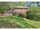 Beautifully landscaped front yard of a two-story brick home with a two-car garage at 1527 Ridgewood Sw Dr, Lilburn, GA 30047