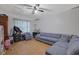 Living room with hardwood floors, windows, ceiling fan, and blue sofa at 1527 Ridgewood Sw Dr, Lilburn, GA 30047