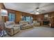 Cozy living room featuring paneled walls, a brick fireplace, and comfortable seating at 1527 Ridgewood Sw Dr, Lilburn, GA 30047