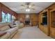 Inviting living room with wood paneling, fireplace, and plush seating near a window at 1527 Ridgewood Sw Dr, Lilburn, GA 30047