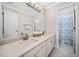 Bright bathroom featuring a double vanity with stone countertops, white cabinetry, and marble tile flooring at 1904 Rosewood Ln, Woodstock, GA 30189